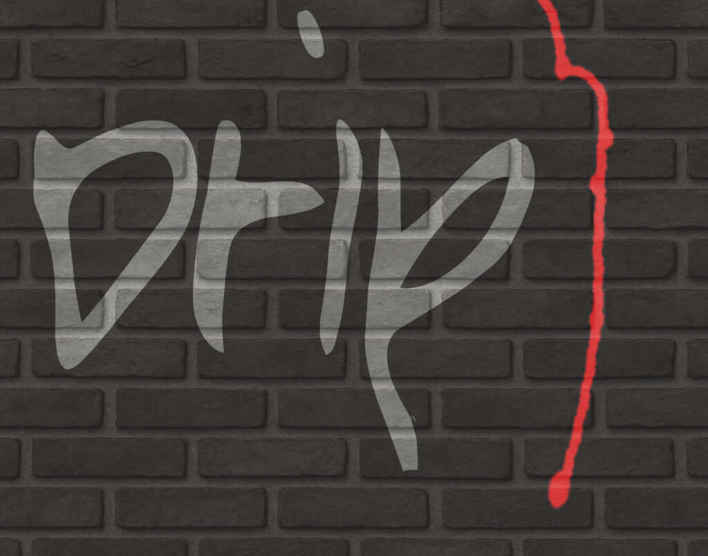 Stylized graffiti on a dark brick wall featuring the word “drip” painted in large, silver-gray letters with organic, fluid curves. To the right, a jagged red vertical line runs down the wall, resembling a streak of paint or blood.